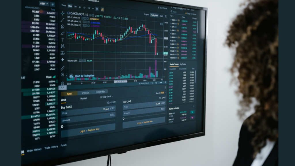 Trader at a desk analyzing charts on a screen with focused expression