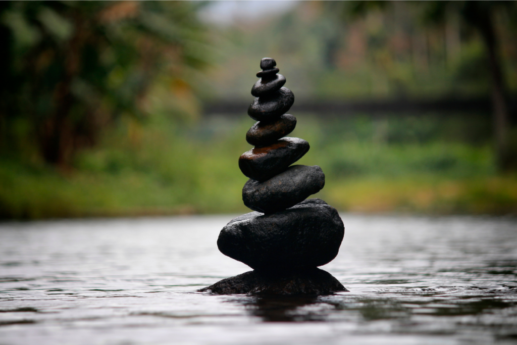 Stacked stones balanced perfectly on top of each other in a serene, natural setting, symbolizing stability, emotional balance, and the importance of consistency in trading.