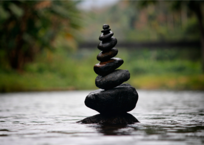 Stacked stones balanced perfectly on top of each other in a serene, natural setting, symbolizing stability, emotional balance, and the importance of consistency in trading.
