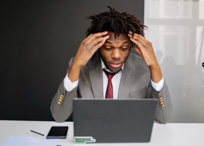 Frustrated trader looking at a laptop, struggling to analyze market charts and price action.