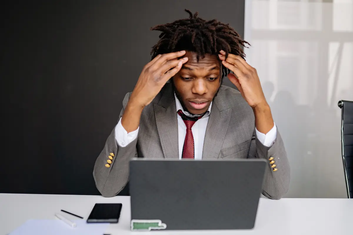 Frustrated trader looking at a laptop, struggling to analyze market charts and price action.